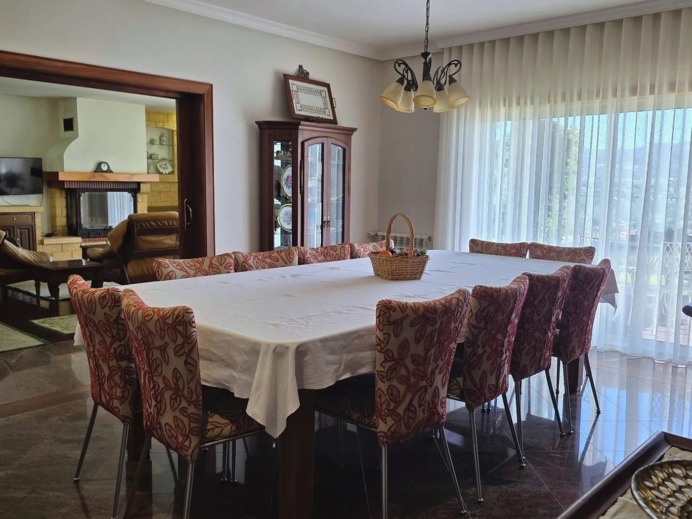 Sala de jantar preparada para uma celebração, ligada à sala da lareira