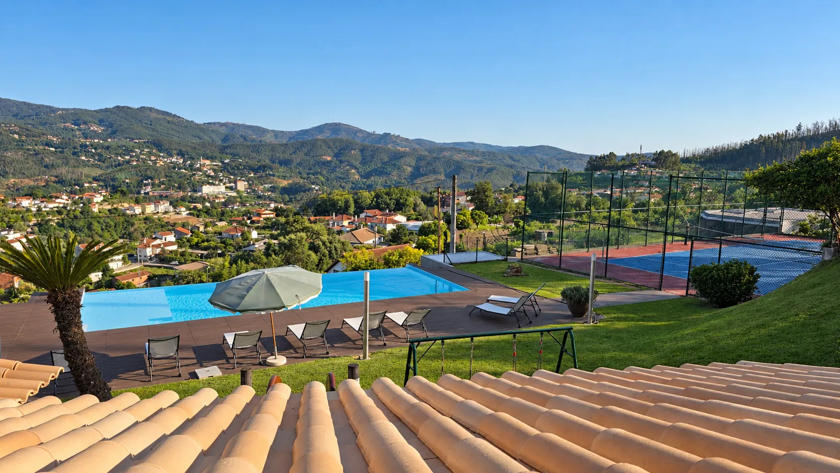 Piscina e campo de ténis vistos da casa