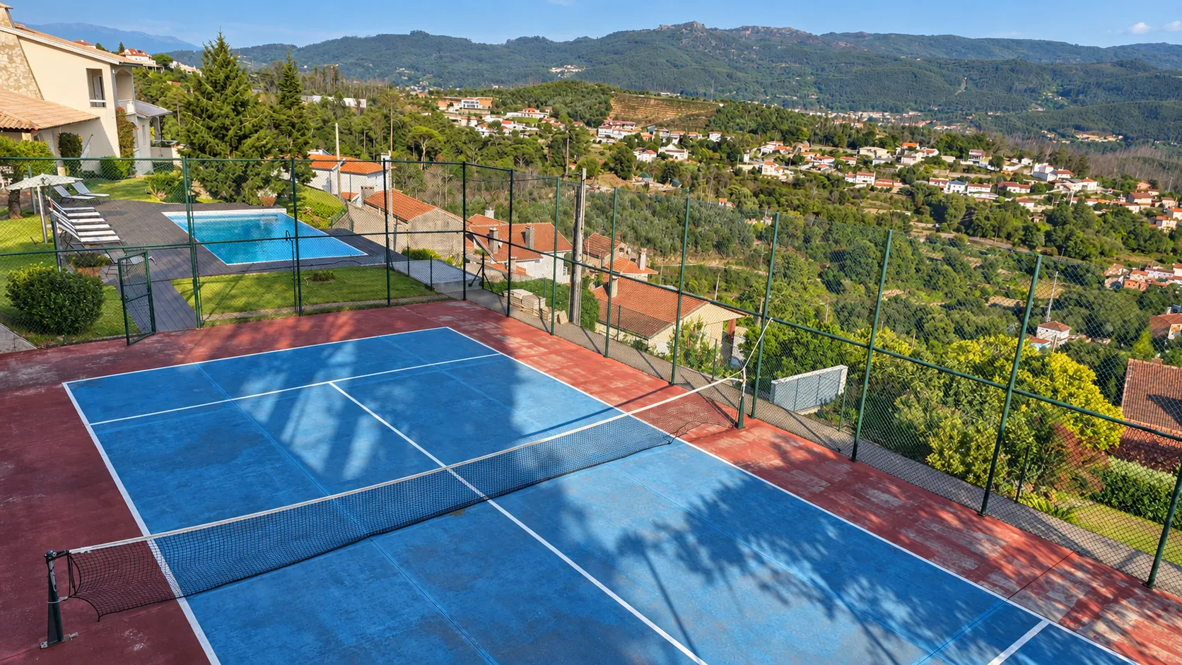 Campo de ténis e piscina com vista sobre a serra